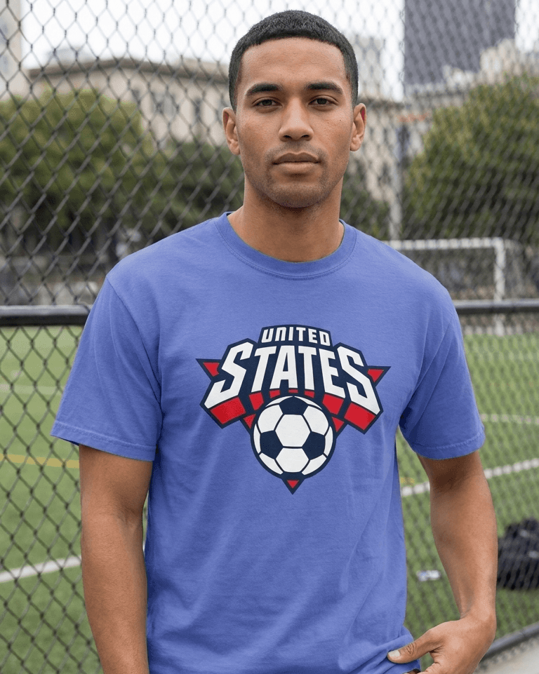 Man wearing a blue t-shirt with a soccer design and 'United States' text, standing outdoors.