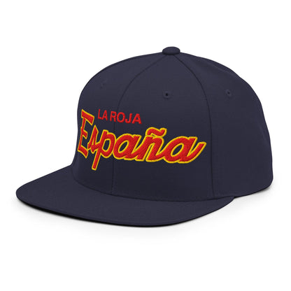A navy blue flat-brim baseball cap with 'LA ROJA' embroidered in red and 'Espana' in large red cursive with yellow outlines on the front.