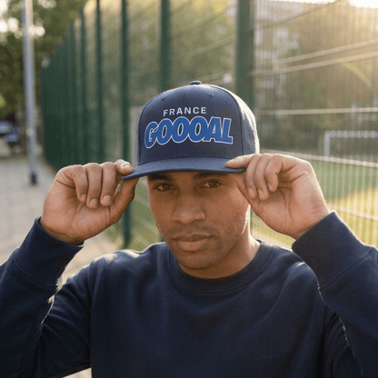 Person wearing a navy blue cap with 'France GOOOAL' text, standing outdoors.