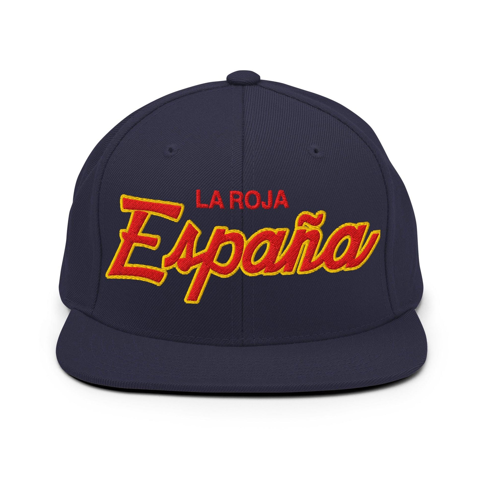 A navy blue snapback cap featuring 'LA ROJA España' embroidered on the front. 'LA ROJA' is embroidered in red block letters, while 'España' is in a large red cursive font with a yellow outline.