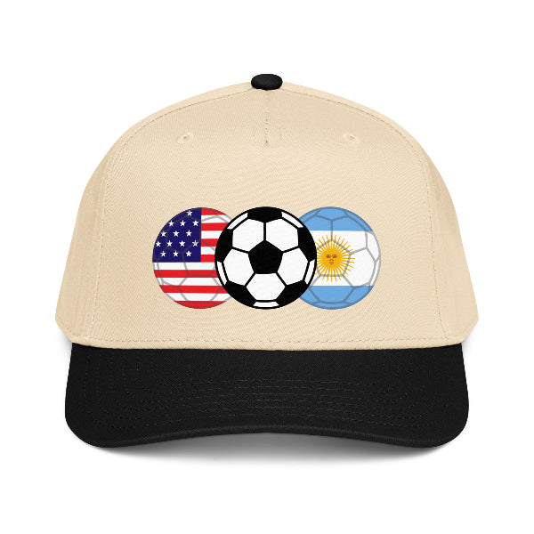 Beige and black snapback hat with soccer ball and American and Argentinian flags on a white background
