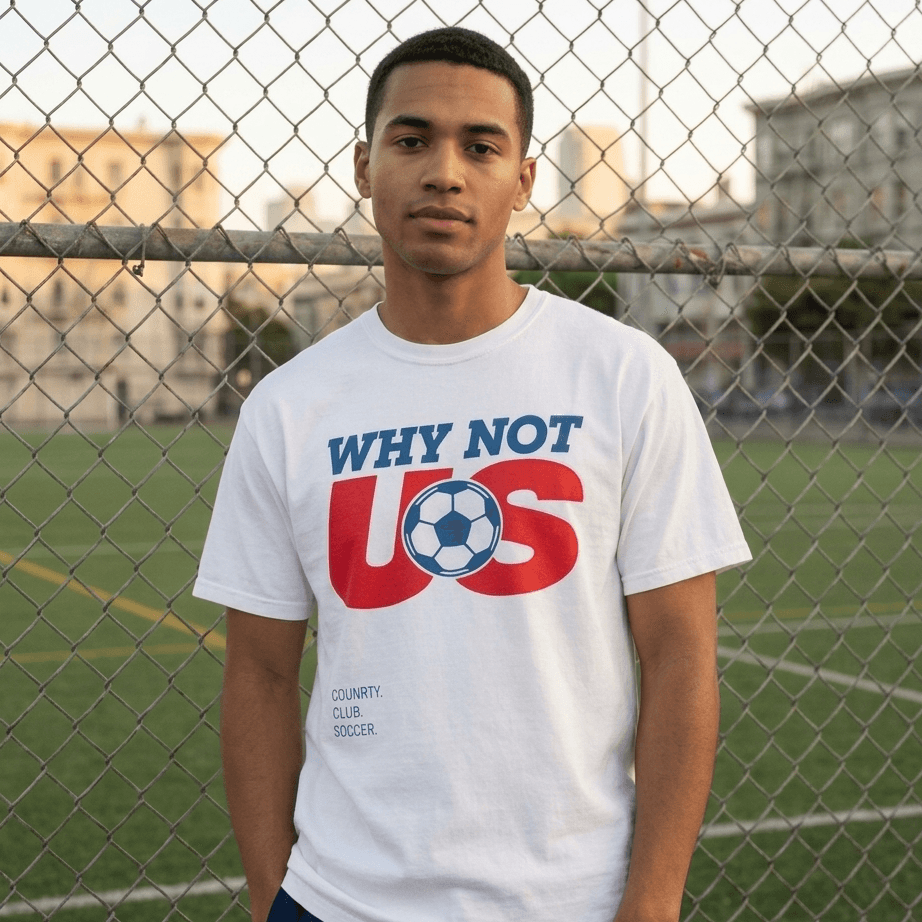 Person wearing a white t-shirt with 'Why Not US' design on a soccer field.